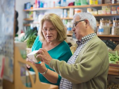 Älteres Paar beim Einkauf im Lebensmittelgeschäft, prüft gemeinsam ein Produkt.